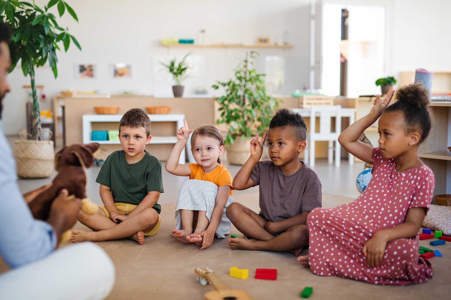 nursery-school-children-with-man-teacher-sitting-o-HHN36BX.jpg